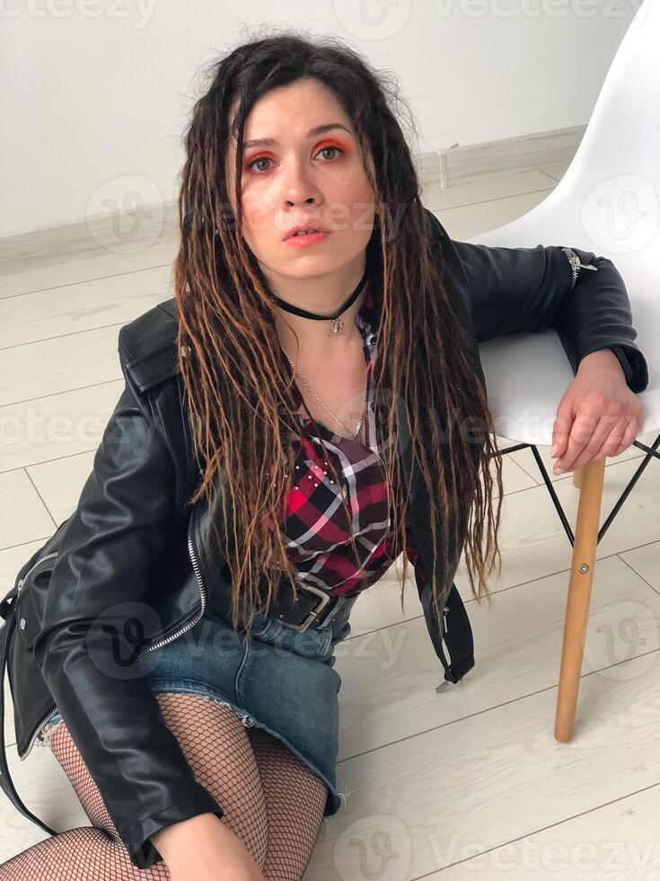 Joyful modern rock style portrait. Woman with dreadlocks and grunge style clothing and make up photo