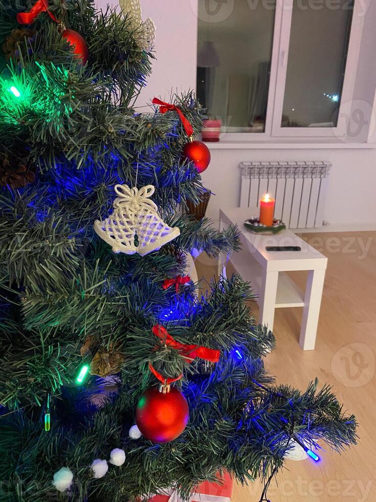 Close-up Festive Christmas tree adorned with colorful lights. Cozy living room and warm holiday atmosphere. photo