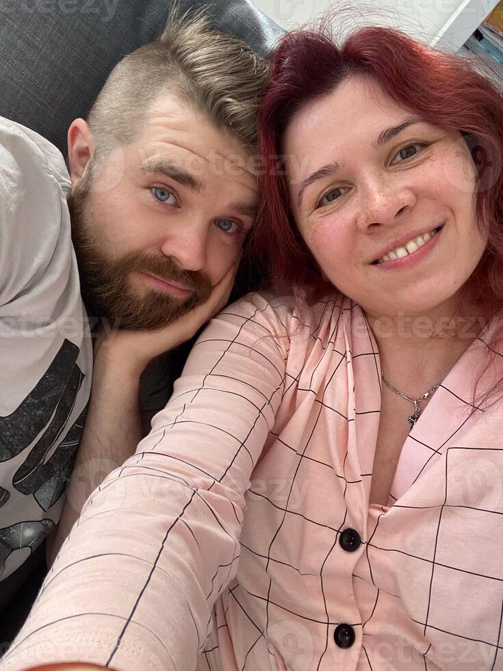 alegre linda joven Pareja disfrutar fin de semana Pareja esposa marido tomar selfie foto juguetón comprar nuevo Departamento adentro dentro casa hogar