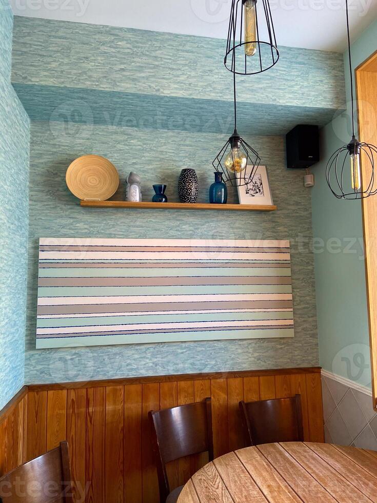 Stylish dining area with modern decorative elements and hanging lights. the harmonious design contemporary art with wooden furniture and pastel colors. Aesthetics, organization and hospitality concept photo