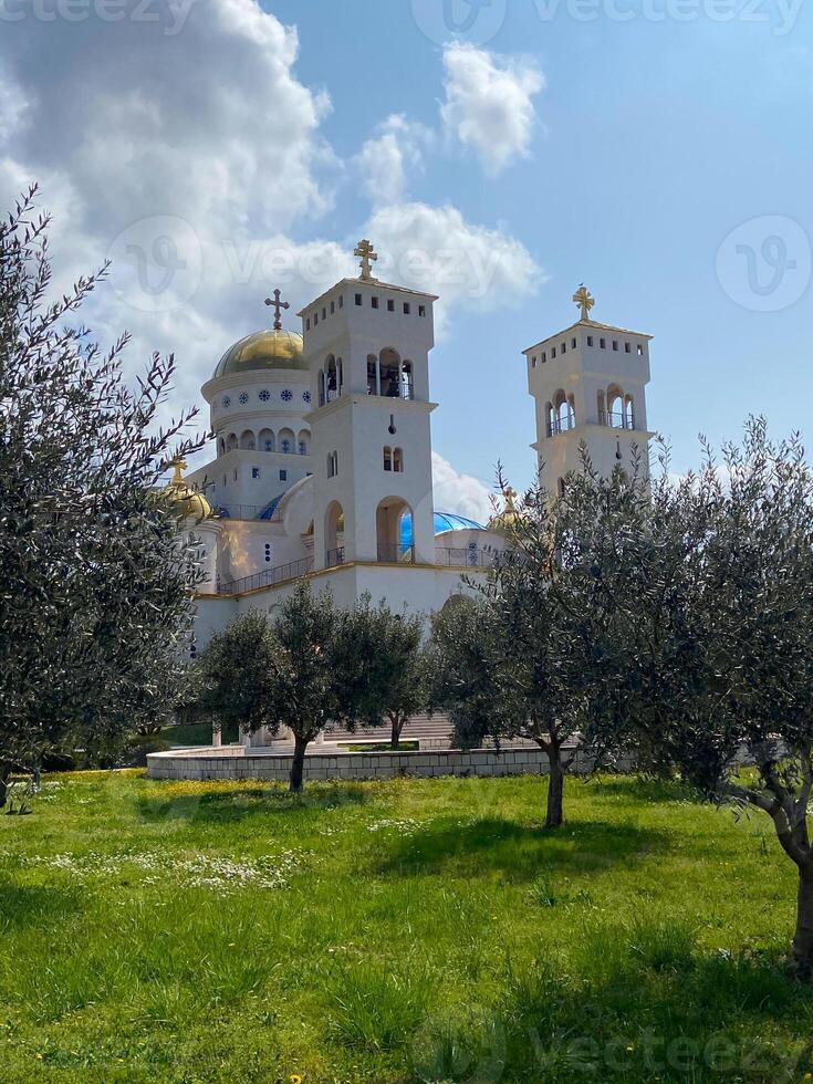 The Cathedral Church of Serbian Saint Jovan Vladimir is one of largest religious Orthodox buildings in Montenegro. Majestic snow-white temple with gilded domes and bells photo