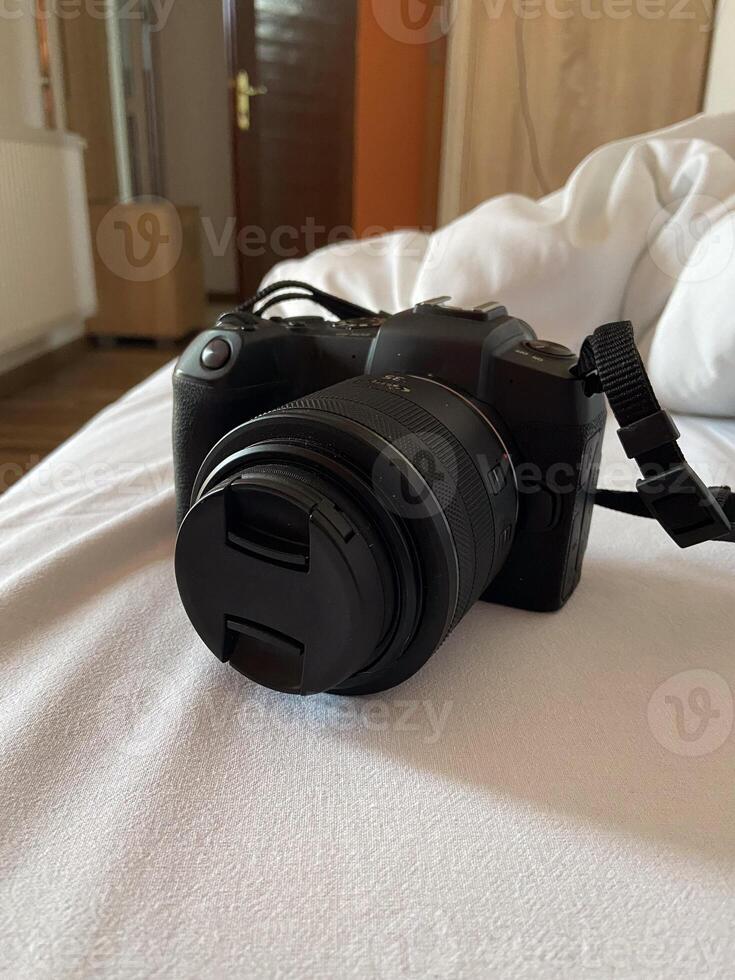 Digital camera rests on a white bed, ready for use, symbolizing creativity and exploration. Relaxed setting suggests a moment of pause before capturing new memories and experiences photo