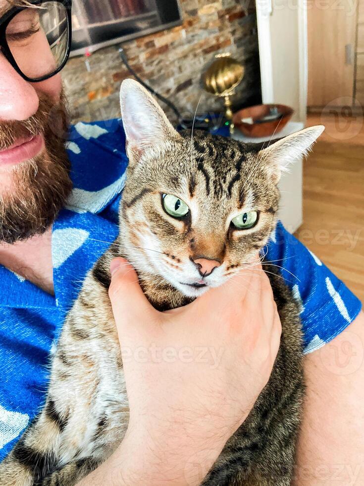 Warm moment between a millennial man and his cat, bond and affection shared in a cozy home environment. Portrait at home. Pet and friendship concept photo