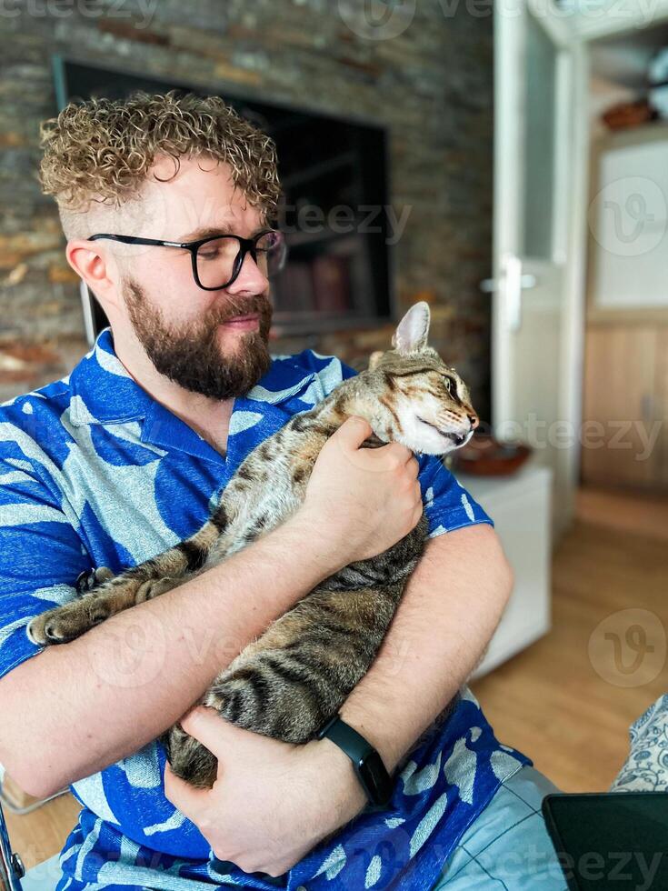 Warm moment between a millennial man and his cat, bond and affection shared in a cozy home environment. Portrait at home. Pet and friendship concept photo