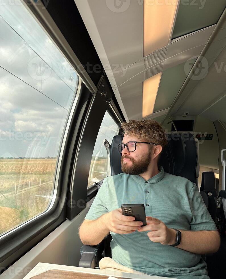 Man traveler enjoying a serene view from a train window. Calm and reflection during a peaceful journey photo
