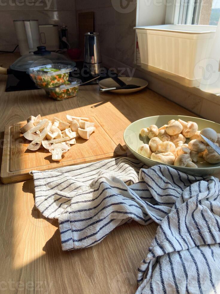 Sunlight in kitchen counter with freshly sliced mushrooms, cooking moment. Simplicity and beauty of food preparation in a home kitchen photo