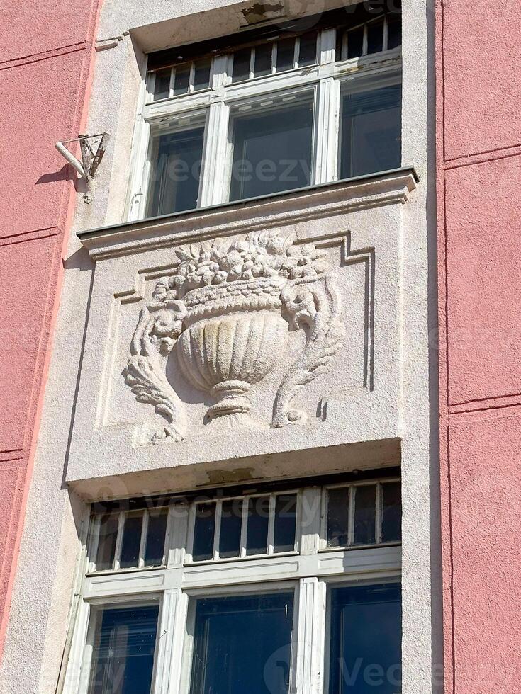 Ornate details of a historic building facade illuminated by sunlight. the intricate architectural elements and pastel colors highlight the building's elegance and charm photo
