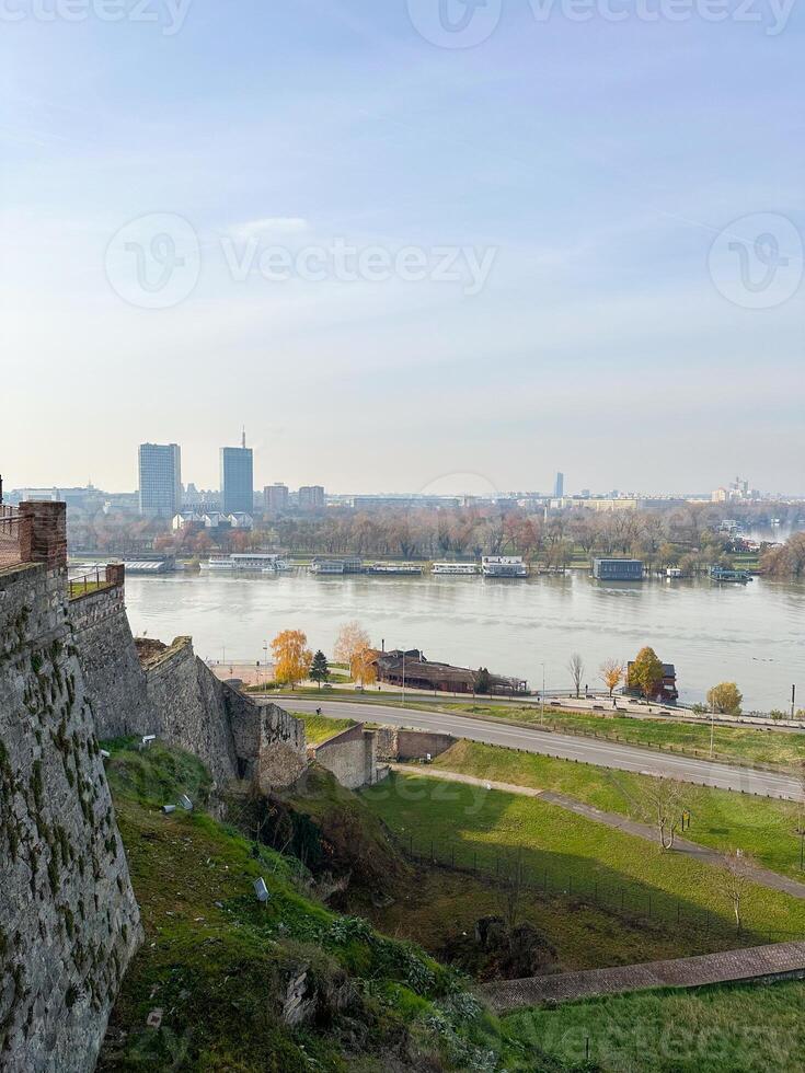 Looking across the Sava river in Belgrade, river boats in the foreground and a variety of office blocks in the distance. Belgrade in autumn season photo