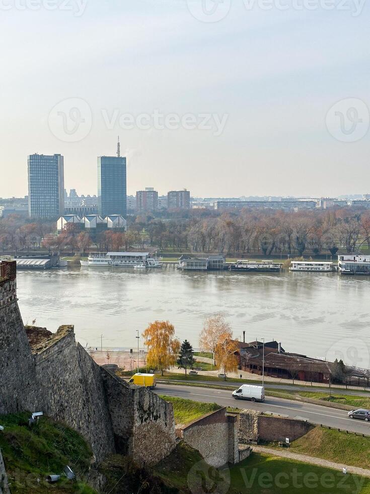 Looking across the Sava river in Belgrade, river boats in the foreground and a variety of office blocks in the distance. Belgrade in autumn season photo