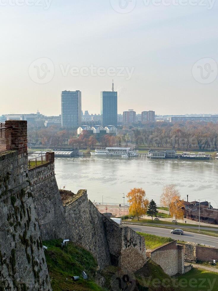Looking across the Sava river in Belgrade, river boats in the foreground and a variety of office blocks in the distance. Belgrade in autumn season photo