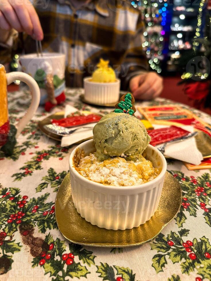Festive dessert table with holiday-themed decorations. a warm crumble topped with a scoop of ice cream and a Christmas tree decoration captures the cozy atmosphere of a winter celebration. photo