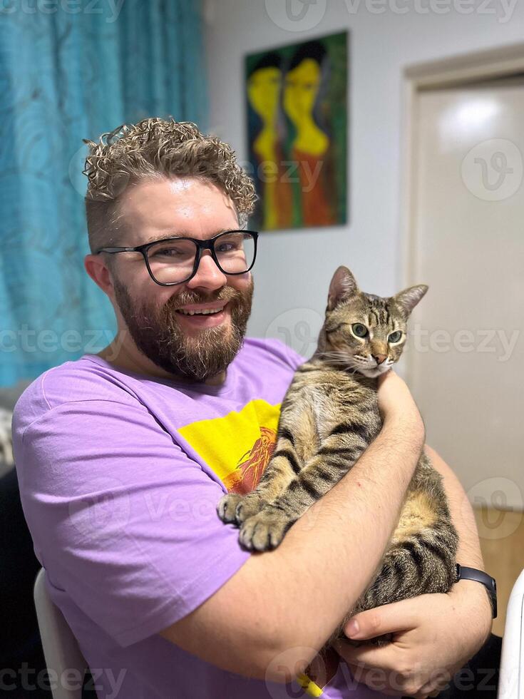 Warm moment between a millennial man and his cat, bond and affection shared in a cozy home environment. Portrait at home. Pet and friendship concept photo