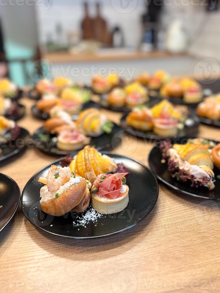 Gourmet appetizers elegantly arranged on black plates. Colorful presentation and variety of flavors, luxurious dining experience. Food and buffet concept photo