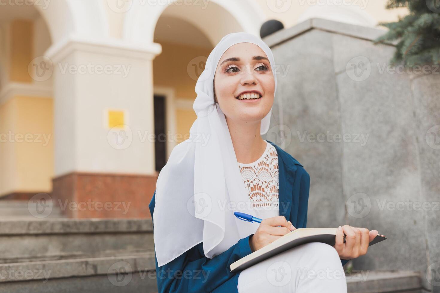 Arab female student sitting on stairs in downtown. photo