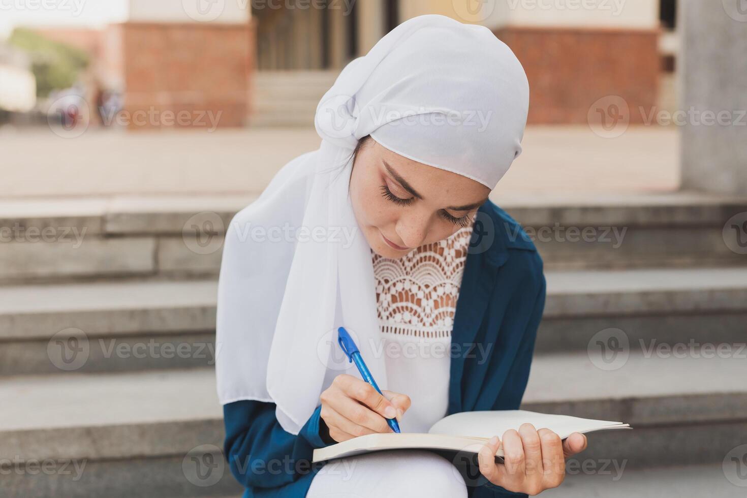 Arab female student sitting on stairs in downtown. photo