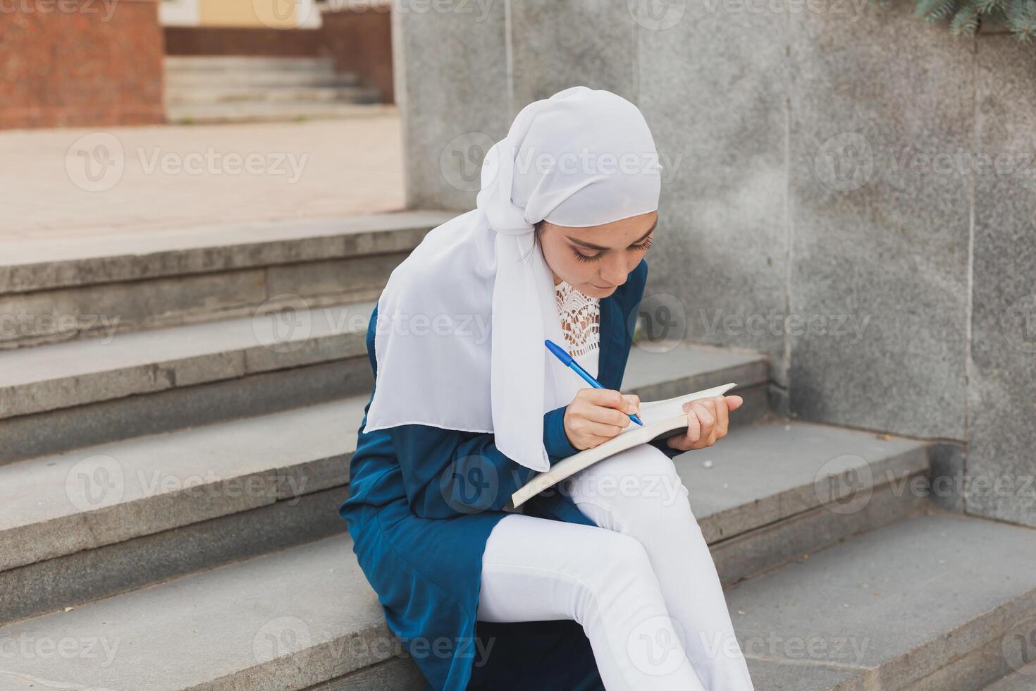 Arab female student sitting on stairs in downtown. photo