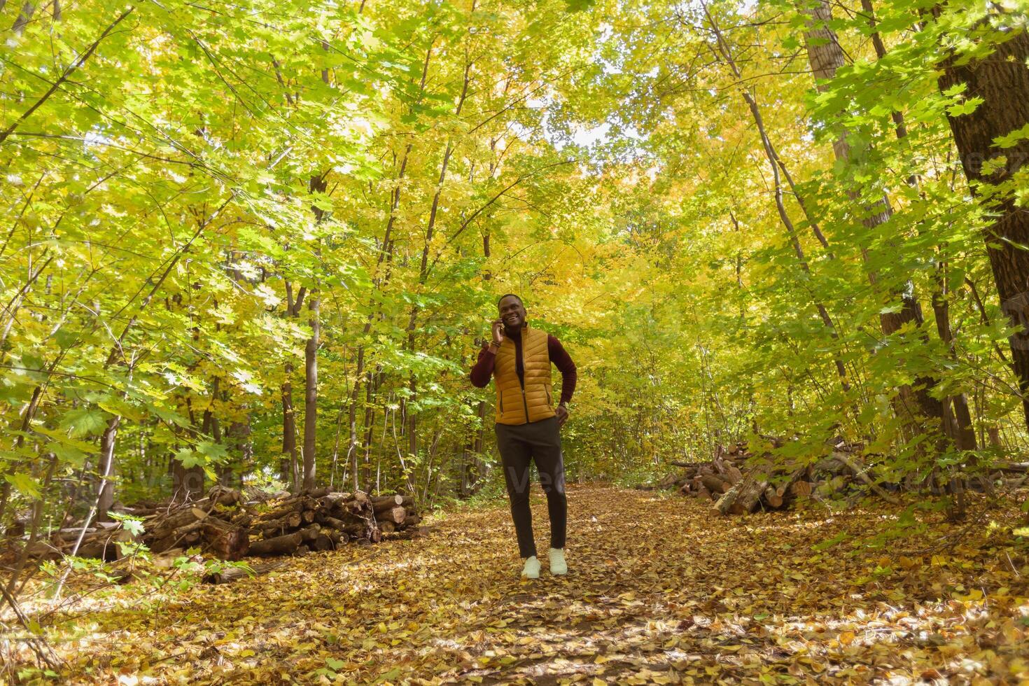 African american student walking in the park in autumn season photo