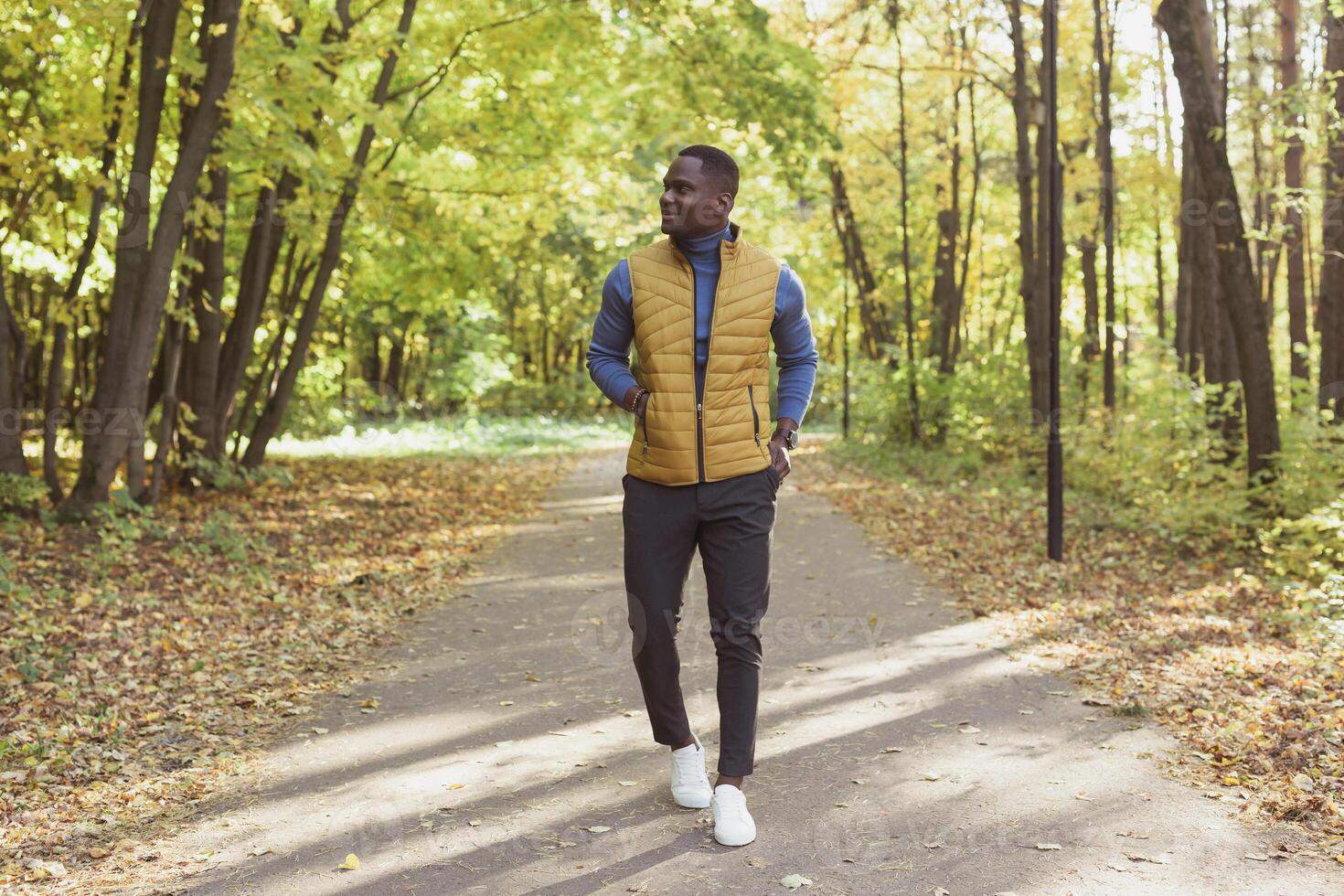 African american student walking in the park in autumn season photo