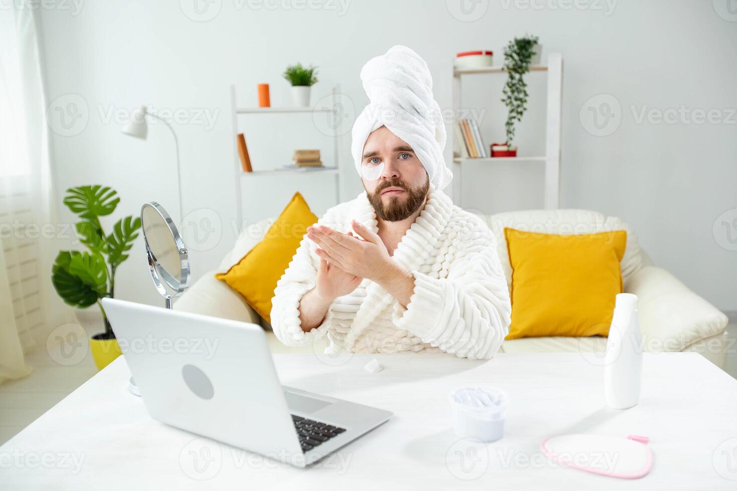 Young man with patches under the eyes at home. Concept of cosmetology for men. Spa at home, body and skin care photo