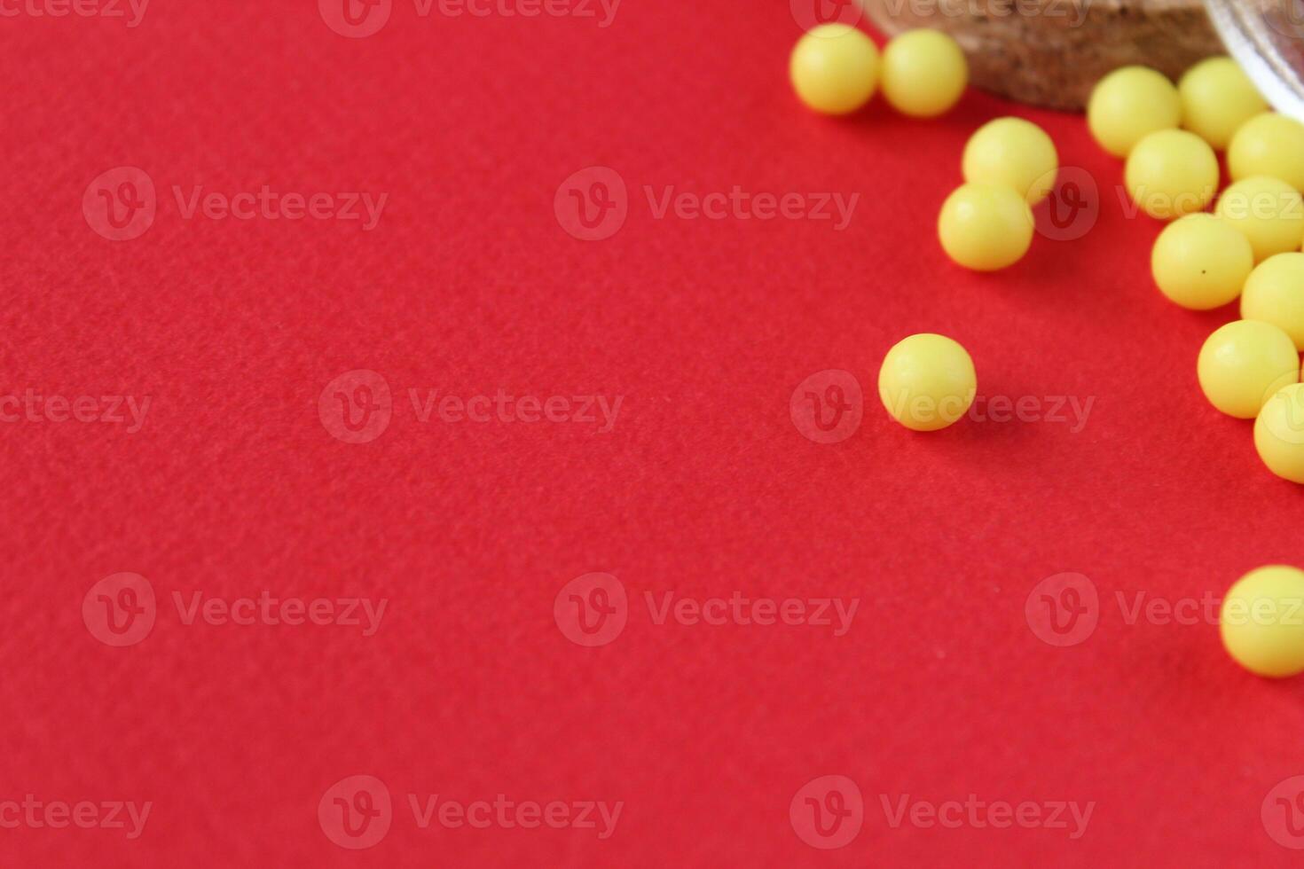 Homeopathy vitamins are scattered on a red background with a copyspace place for text. photo