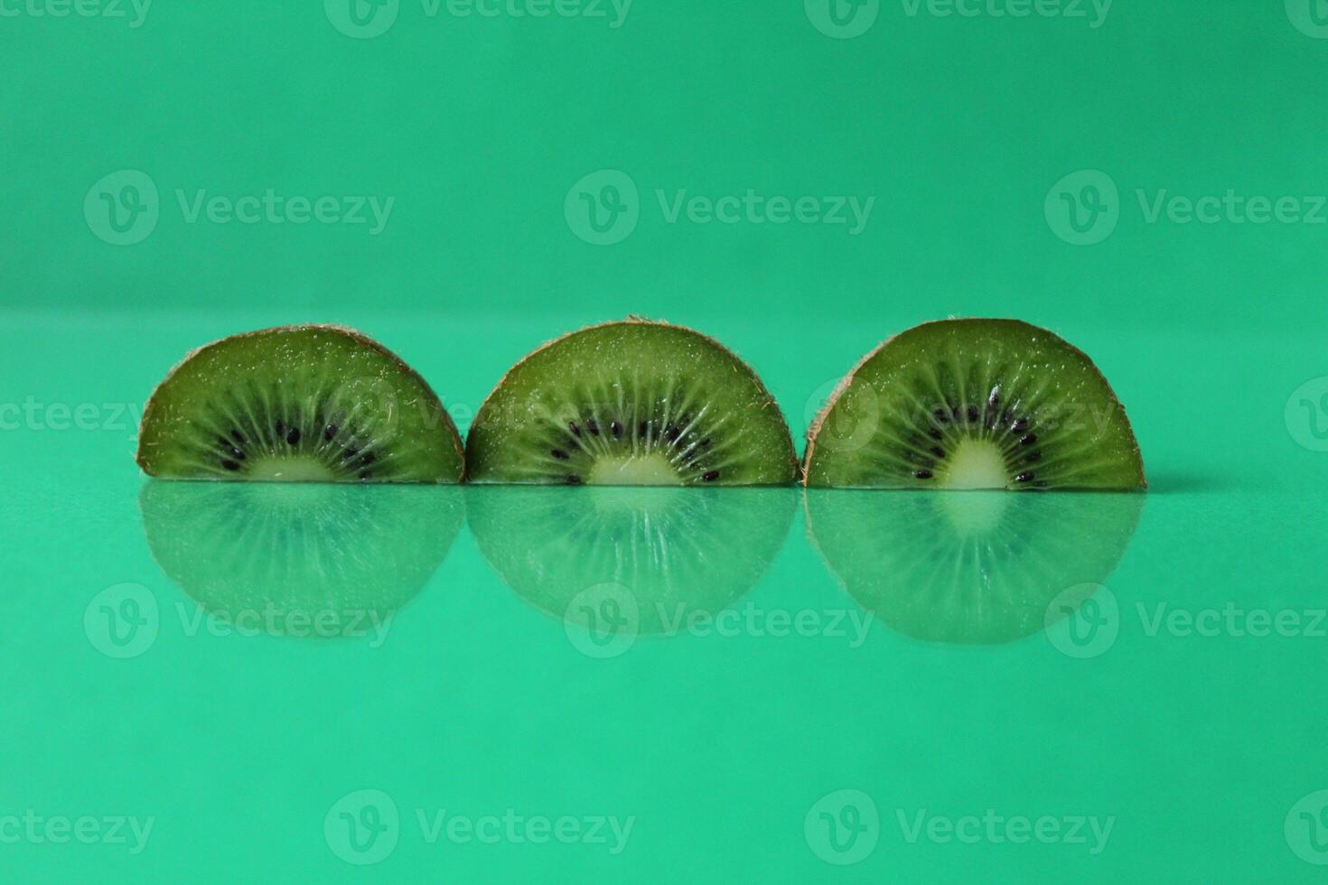 Green still life circles semicircular kiwi pieces with flipped on green with copyspace photo