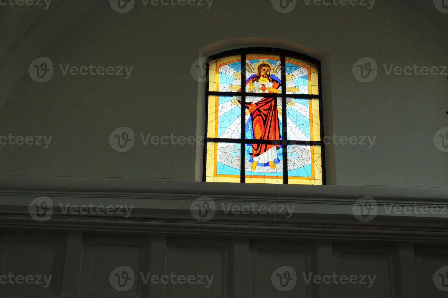 Stained glass on the window on a gray background with space for copyspace text. Stained-glass window in the church, temple, catholic photo