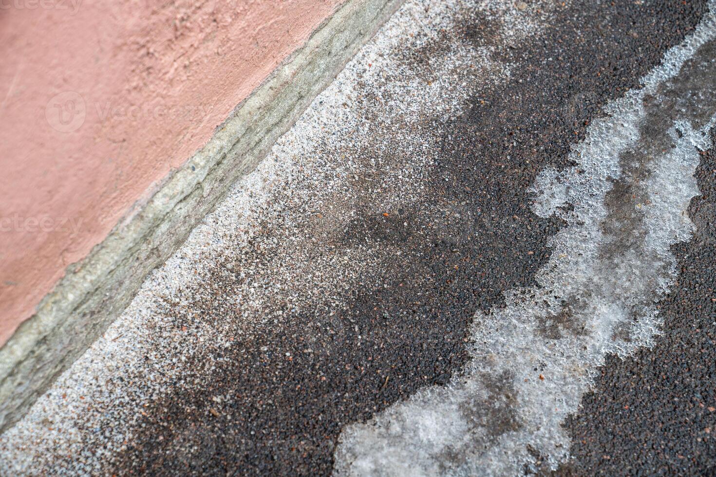Deicing chemicals on pavement in winter. Salt grains on icy sidewalk paving slab with technical salt photo
