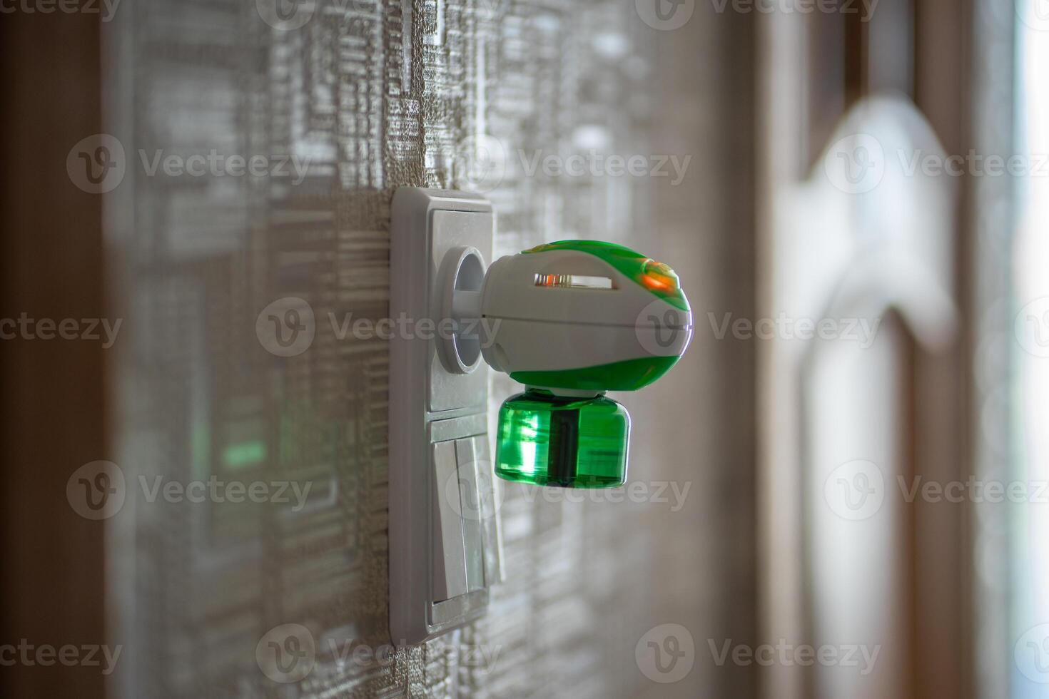 Mosquito repellent with plug into the socket at home. Electric insect repellent diffuser closeup photo