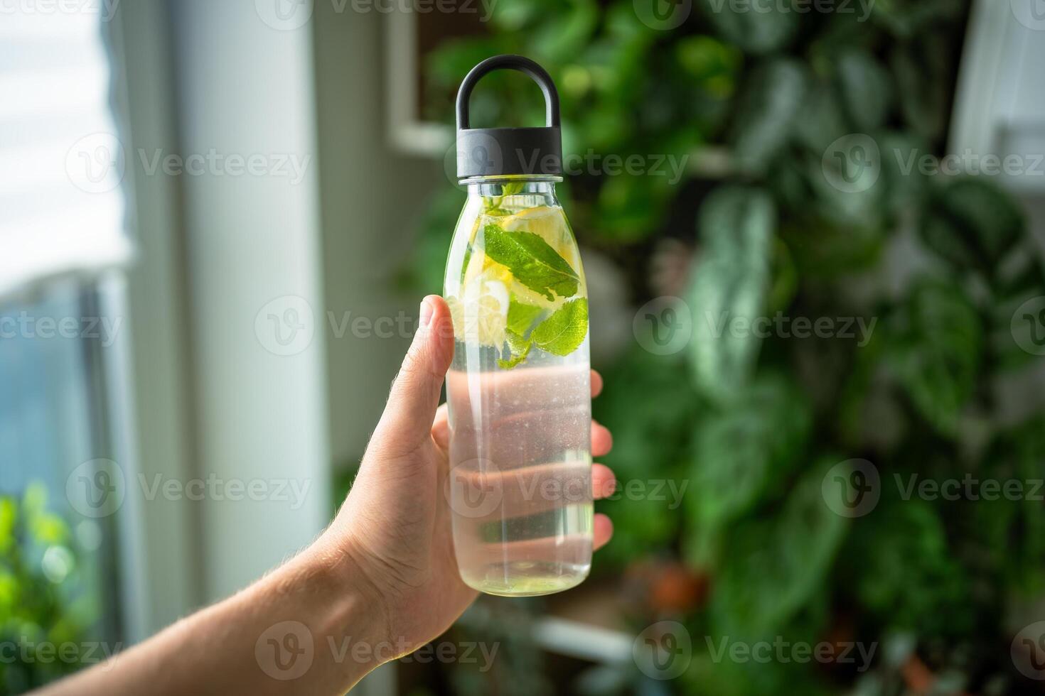 Water with mint, thyme, lime for drinking outside in hot weather, bottle with mint and lemon water photo