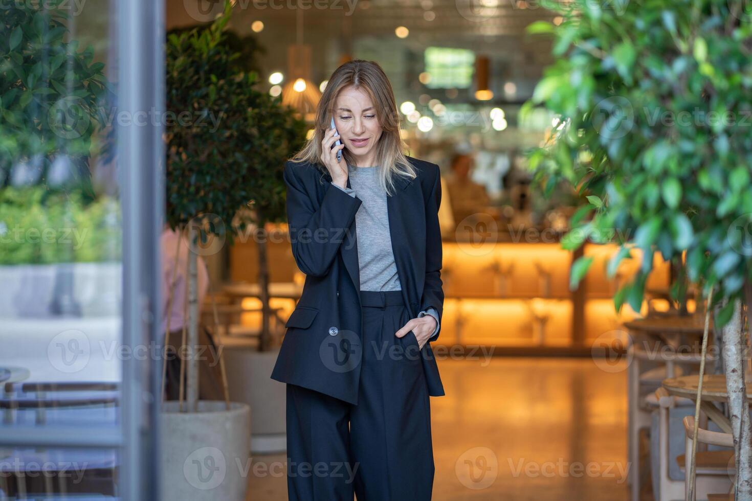 Focused on phone call confident pleased woman cafe owner remotely resolves small business issues. photo