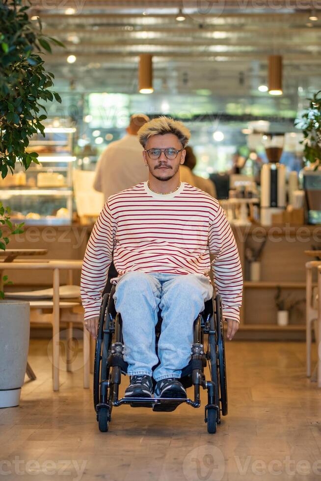 Calm man with disability in wheelchair moves around coffeeshop. Accessible environment for everyone. photo