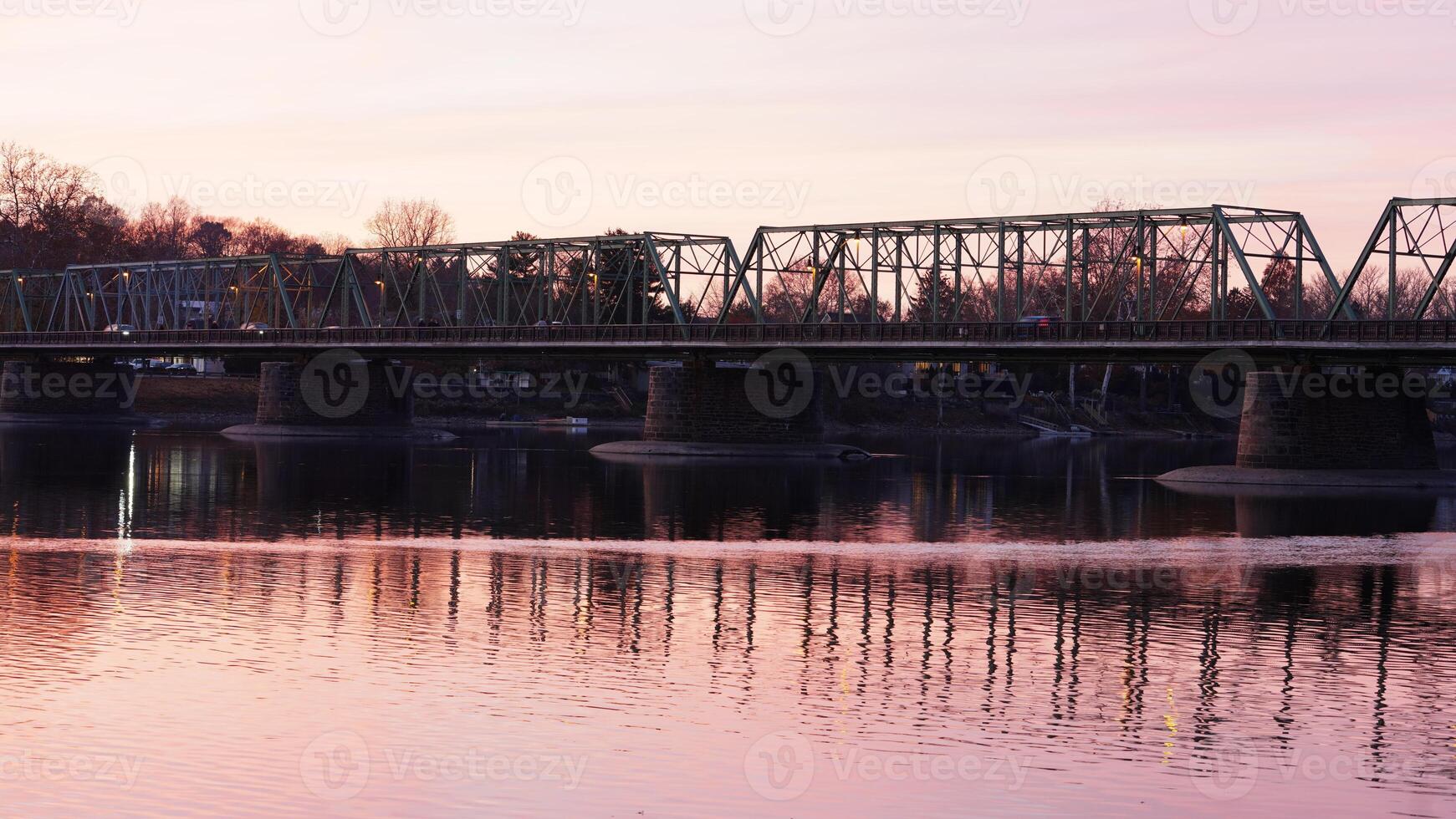 One old rion frames bridge view on the river with the sunset sky as background photo