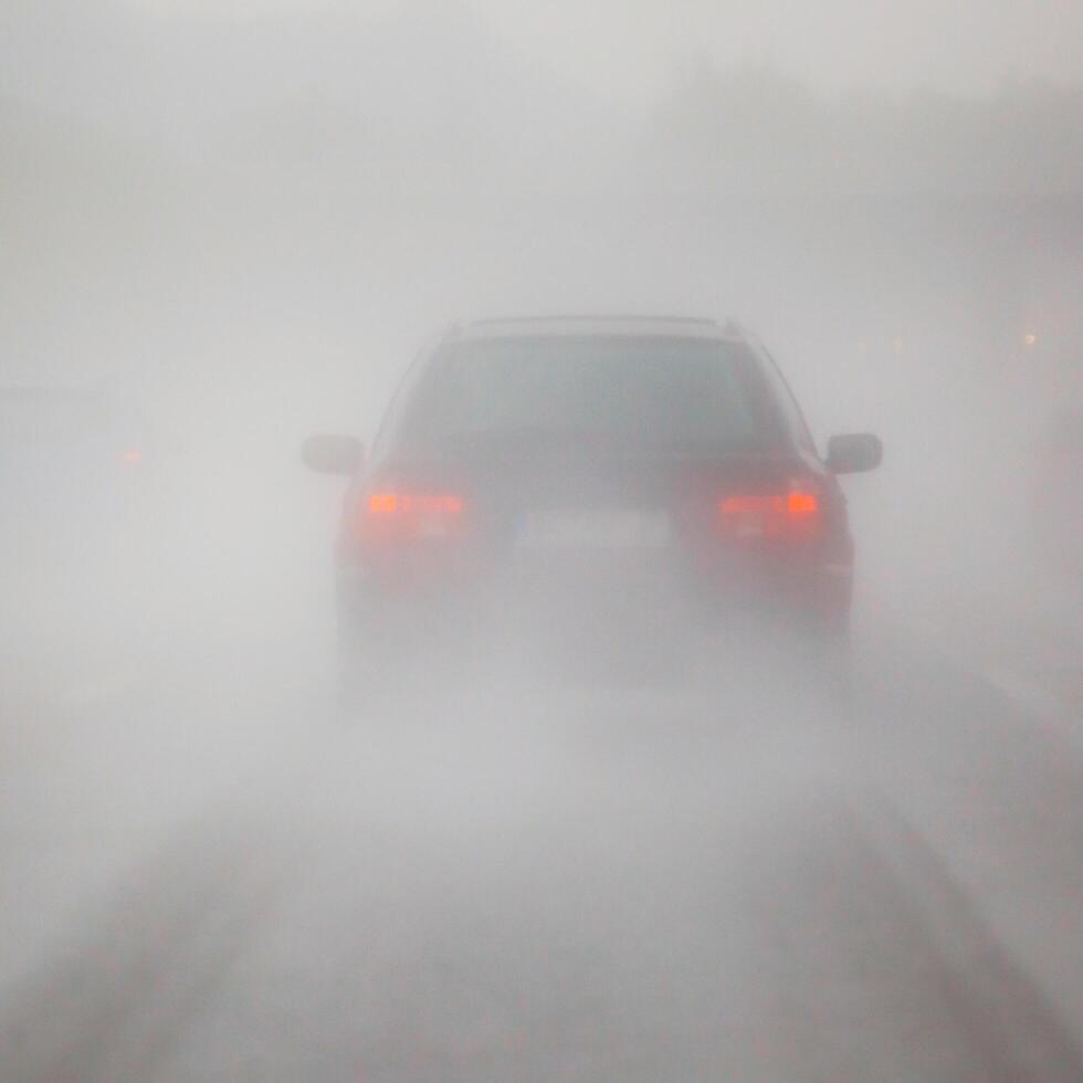 a car driving through a foggy road photo