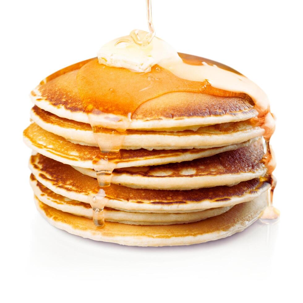 a stack of pancakes with syrup being poured on top photo