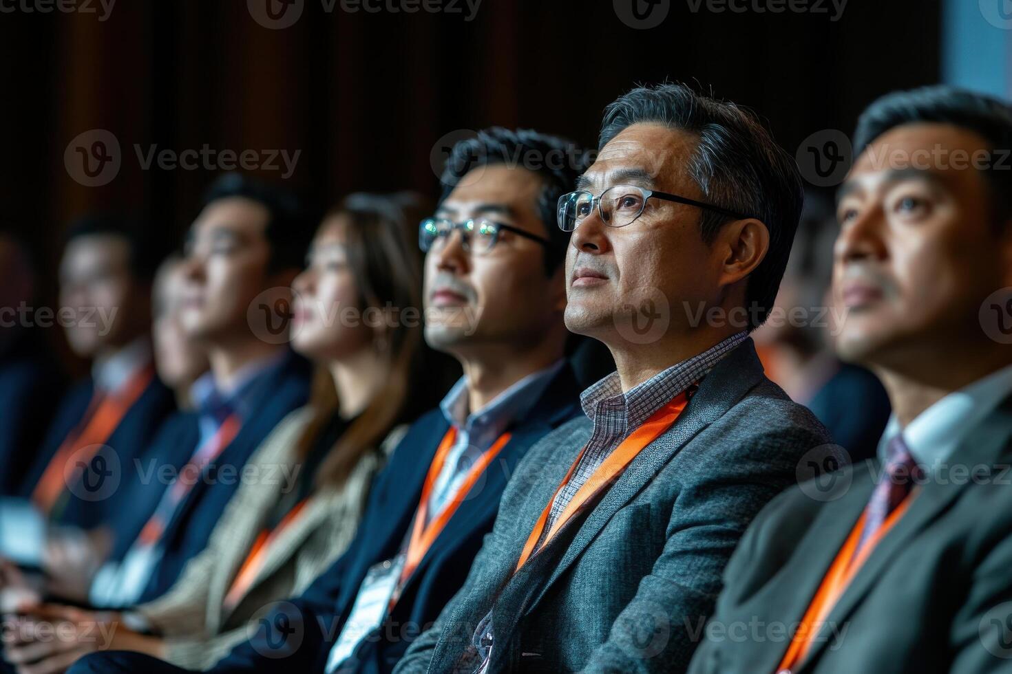 Diverse group of Asian professionals attending business conference listening to speaker photo