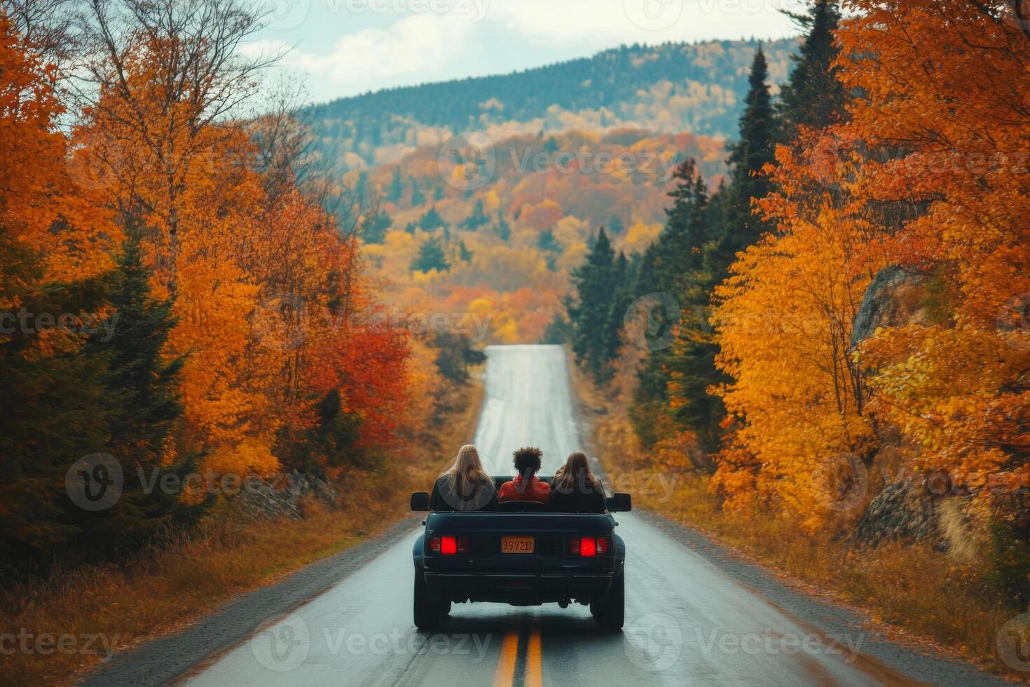 Three People Driving Through a Scenic Fall Foliage Road photo