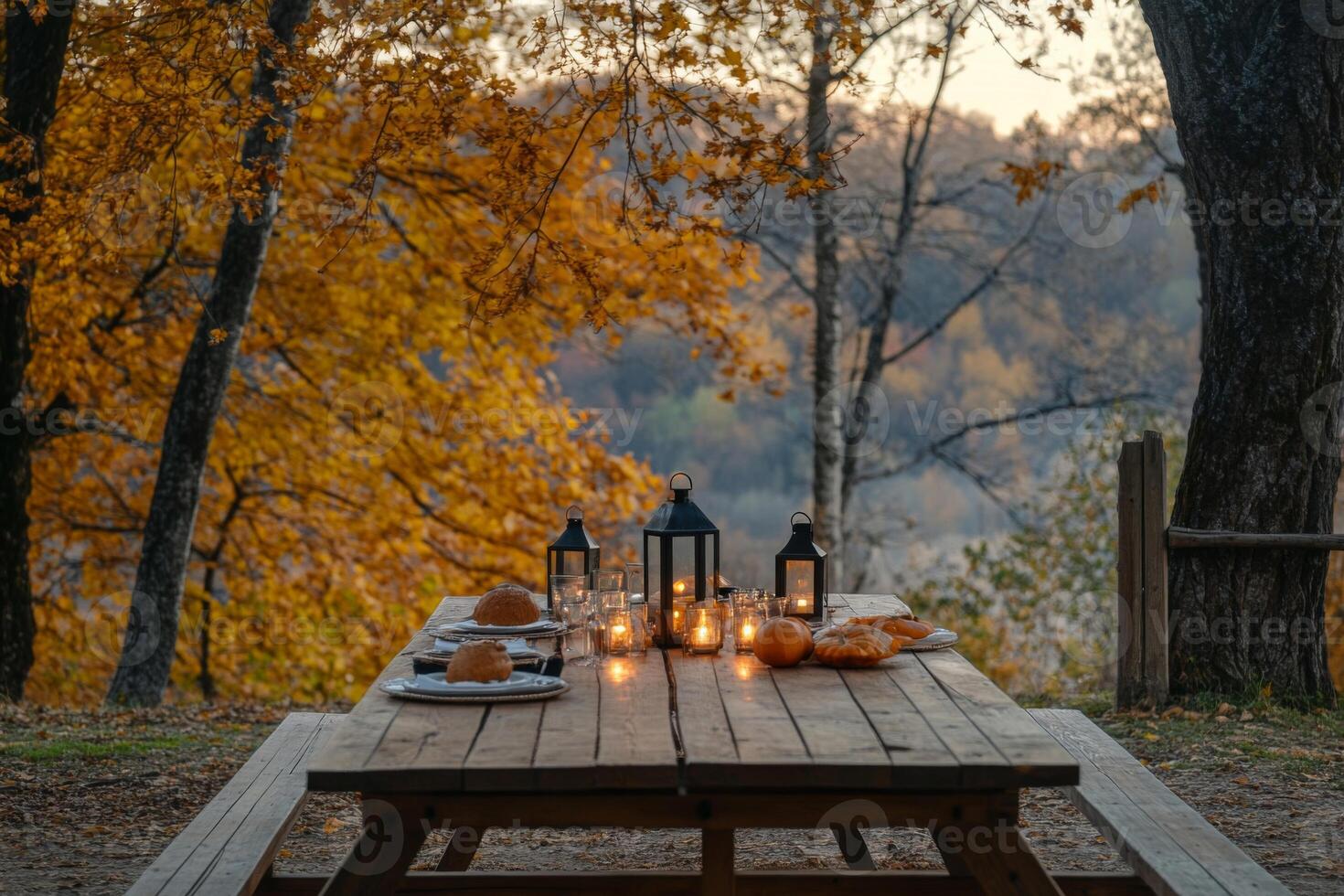 Rustic Table Setting with Lanterns and Pumpkins in an Autumn Forest photo