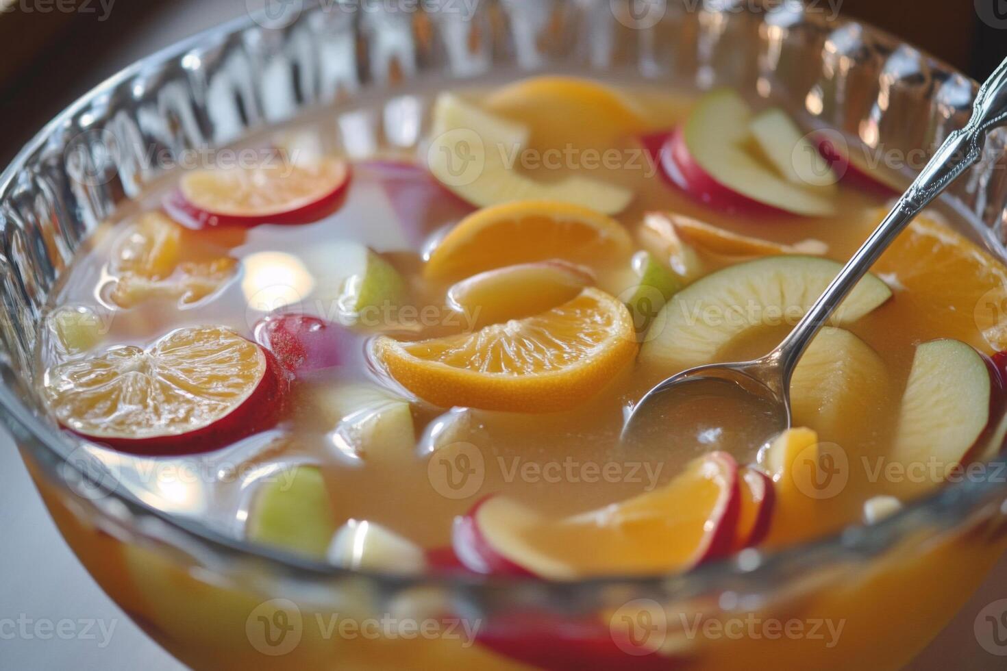 Fruit Punch with Slices of Apple, Orange, and Red Fruit in a Glass Bowl photo