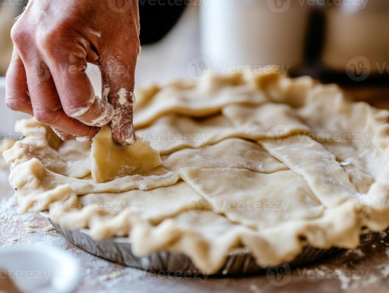 A Hand Placing a Piece of Dough Over a Pie Crust photo