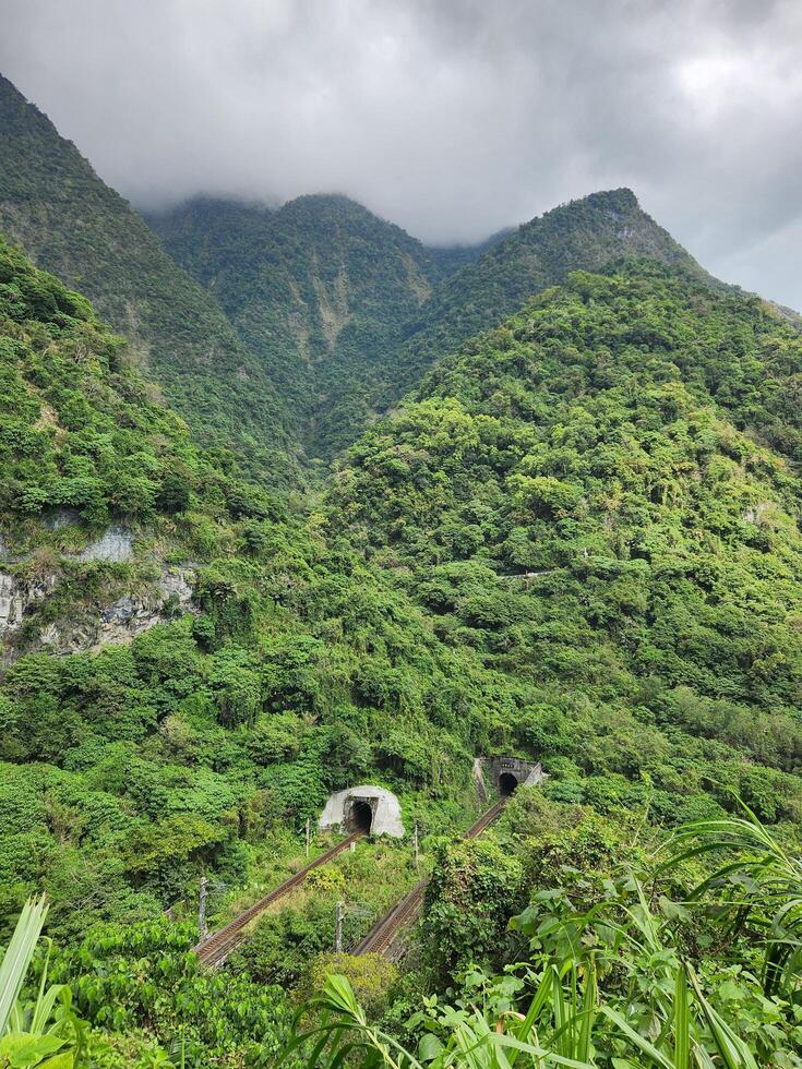 A train is traveling through the mountains on a cloudy day photo