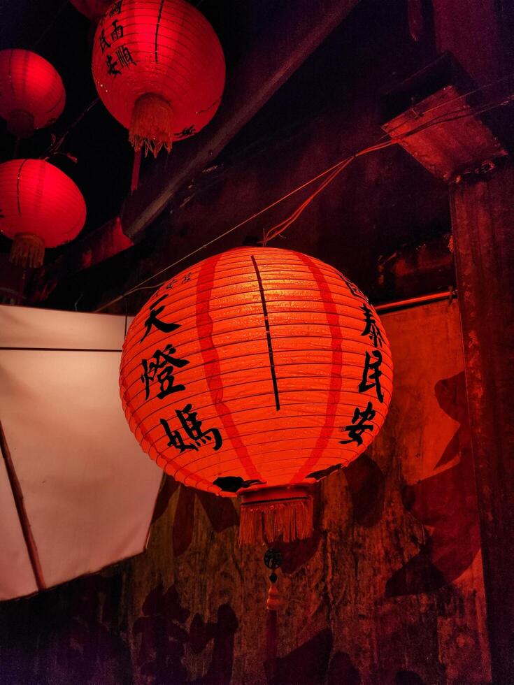 A red lantern hanging from a ceiling photo