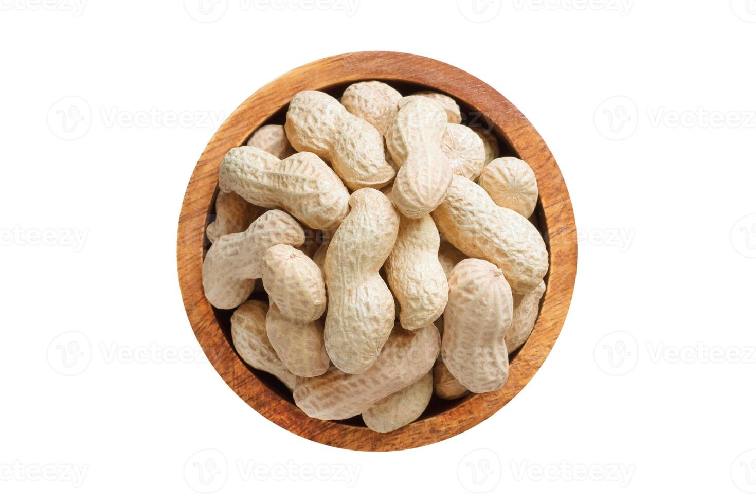 shelled peanut in wooden bowl isolated on white background. Vegan food, top view. photo