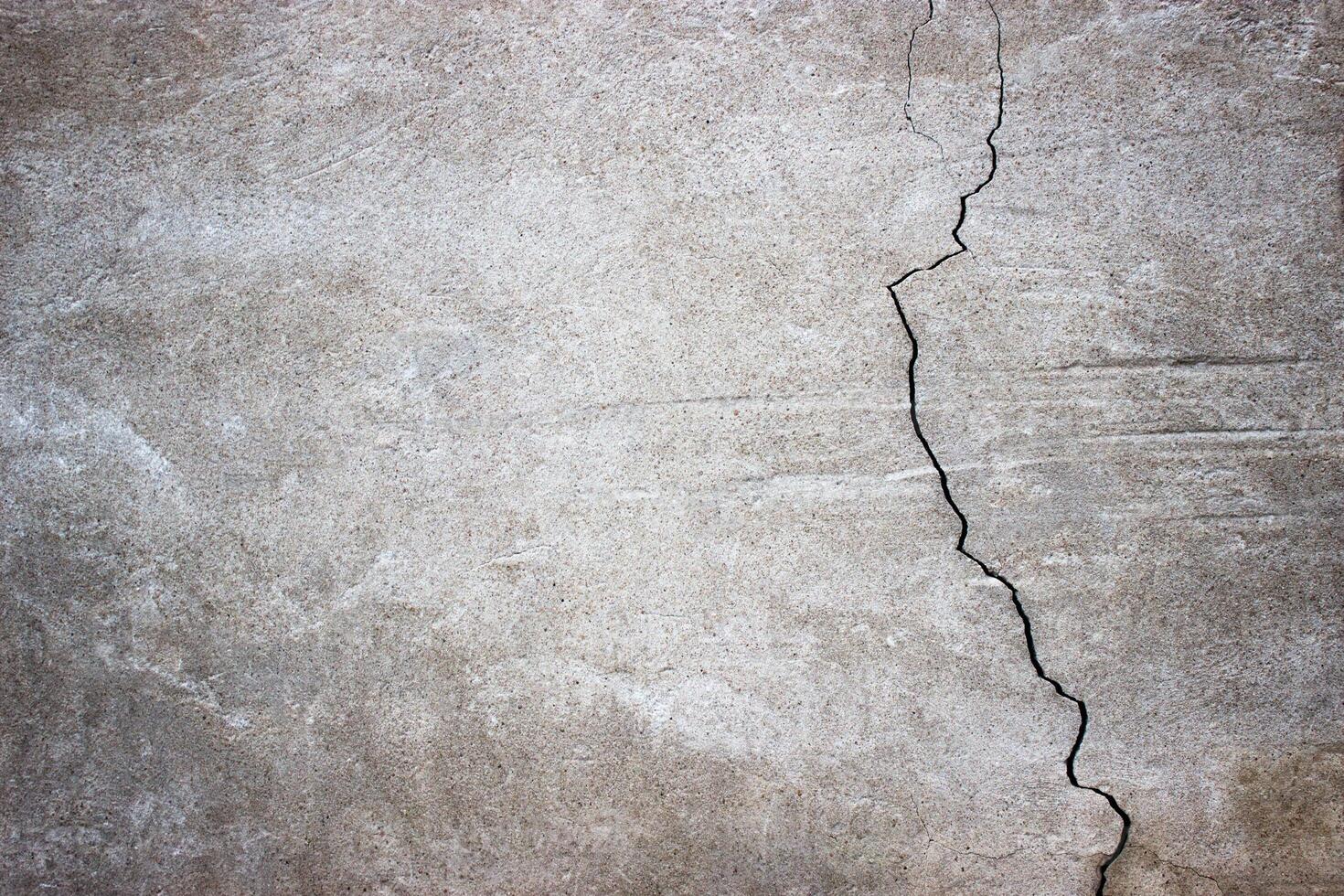 cracked concrete wall covered with gray cement surface as background photo