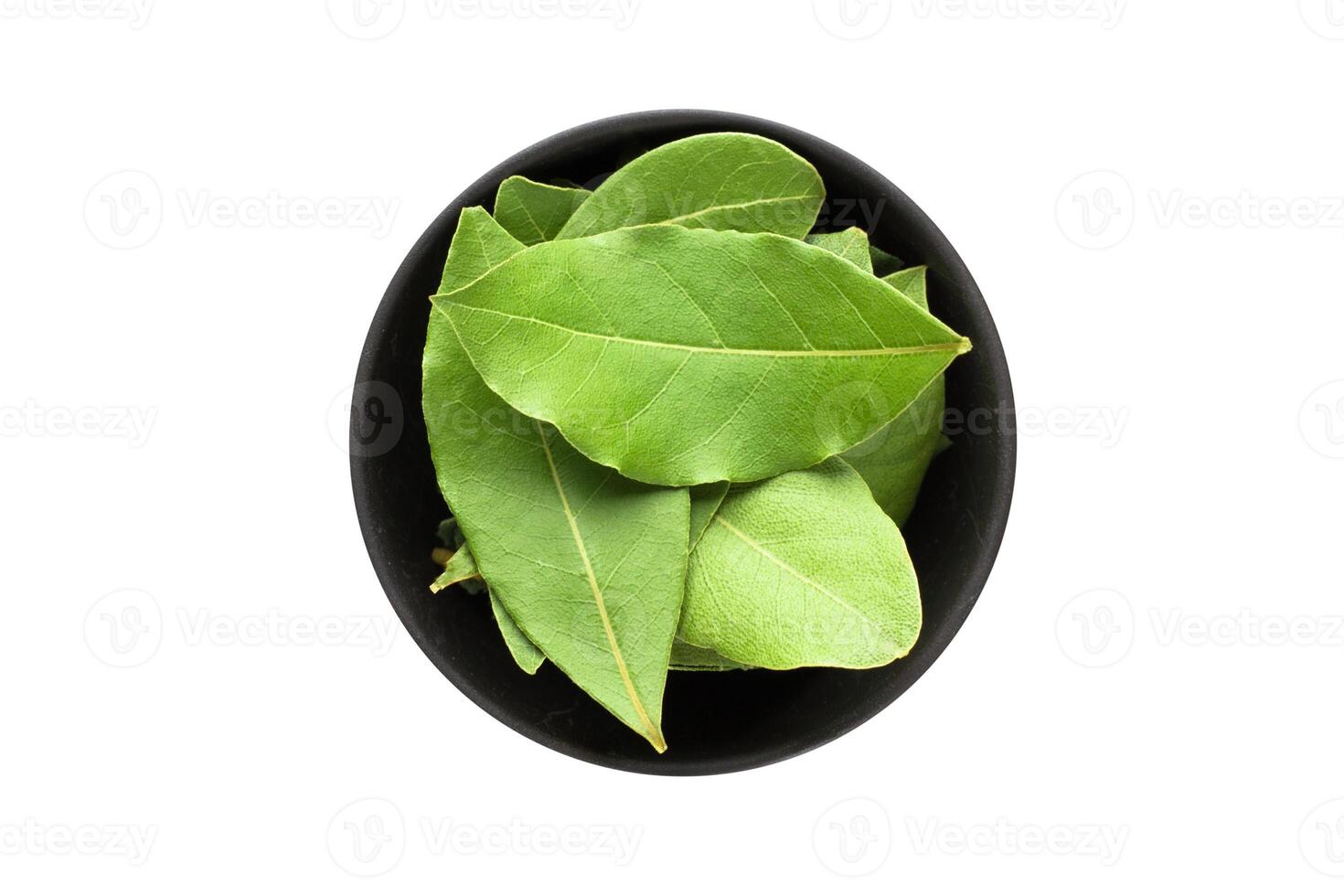 dried bay leaves in clay bowl isolated on white background. Seasoning or spice top view photo