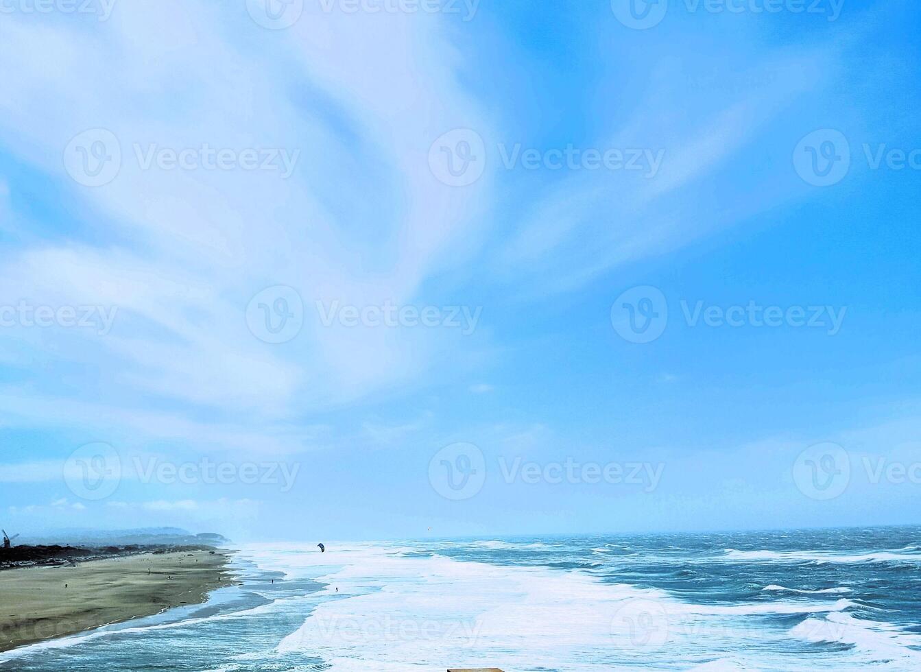A man sitting on a bench overlooking the ocean photo