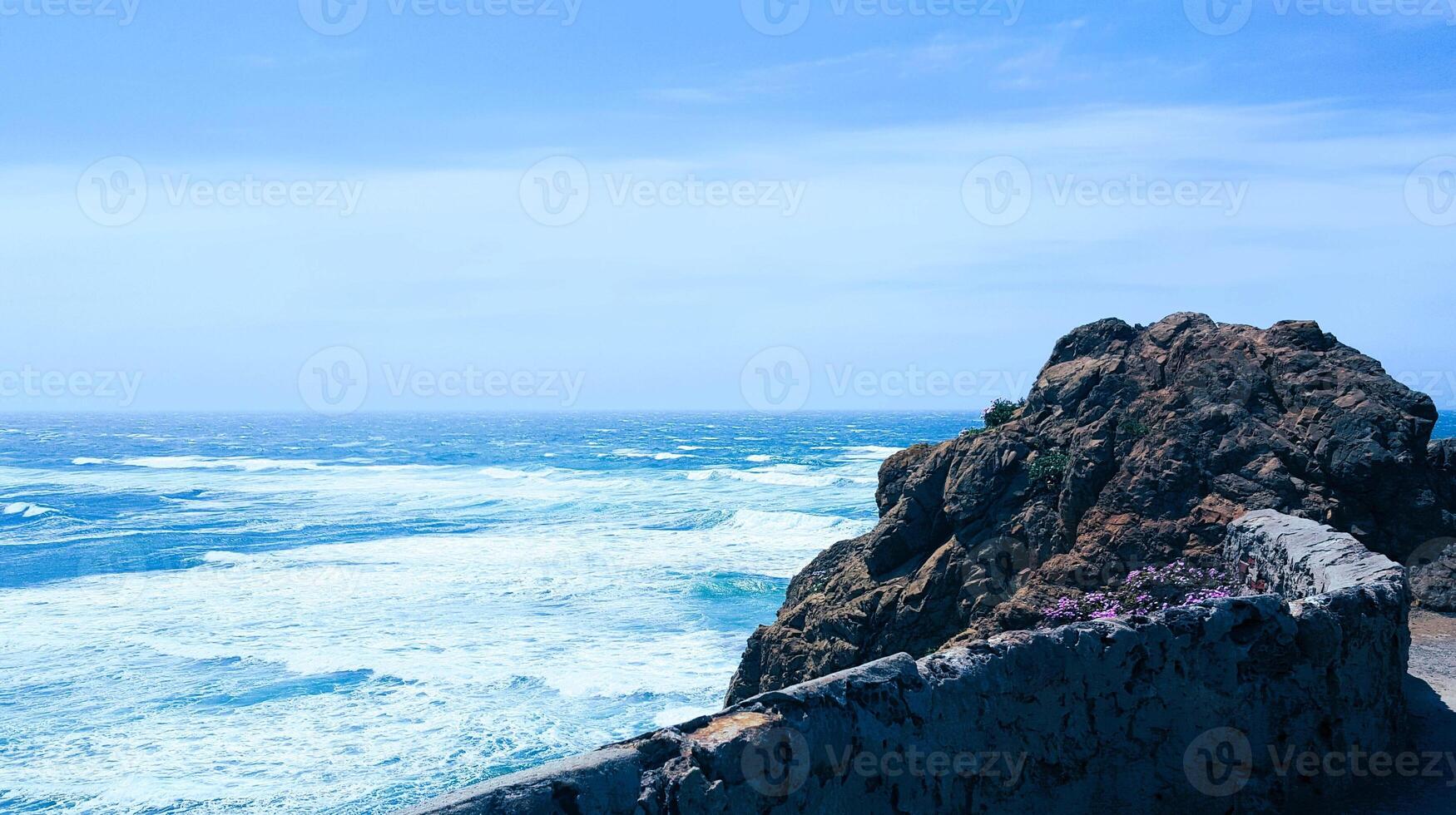 A rocky cliff overlooking the ocean photo