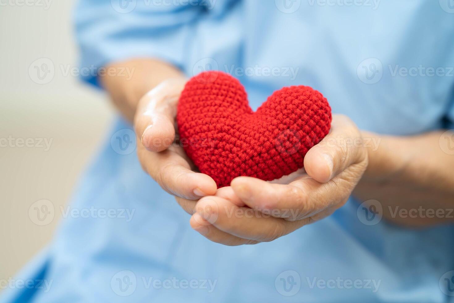 Asian doctor give red heart to elderly woman in her hand, heart Attack. photo