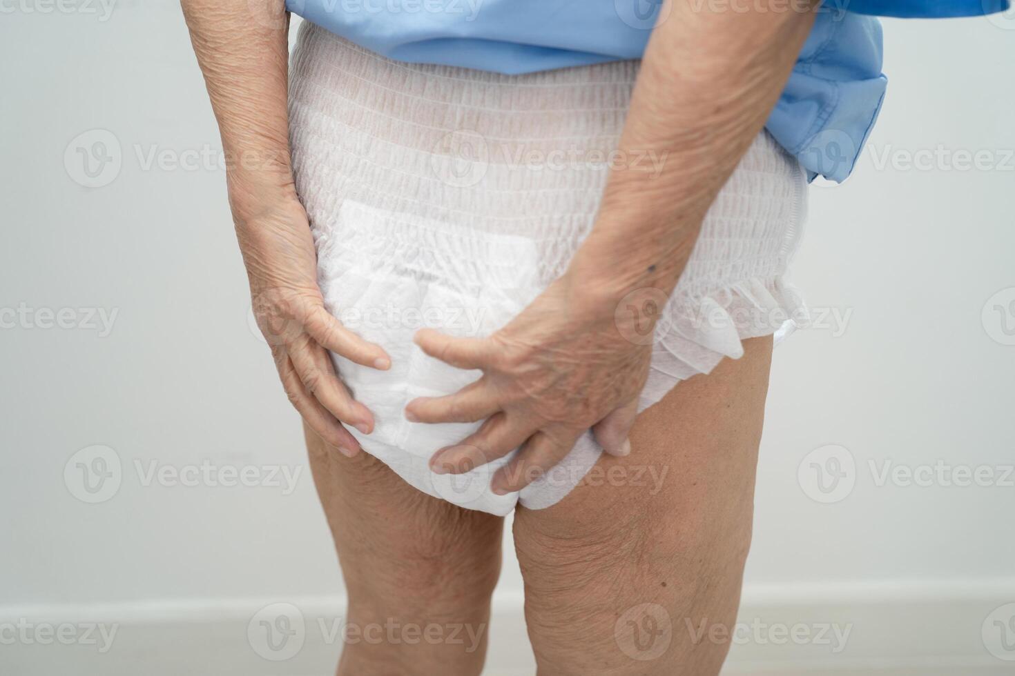 Asian senior woman patient wearing adult incontinence diaper pad in hospital. photo