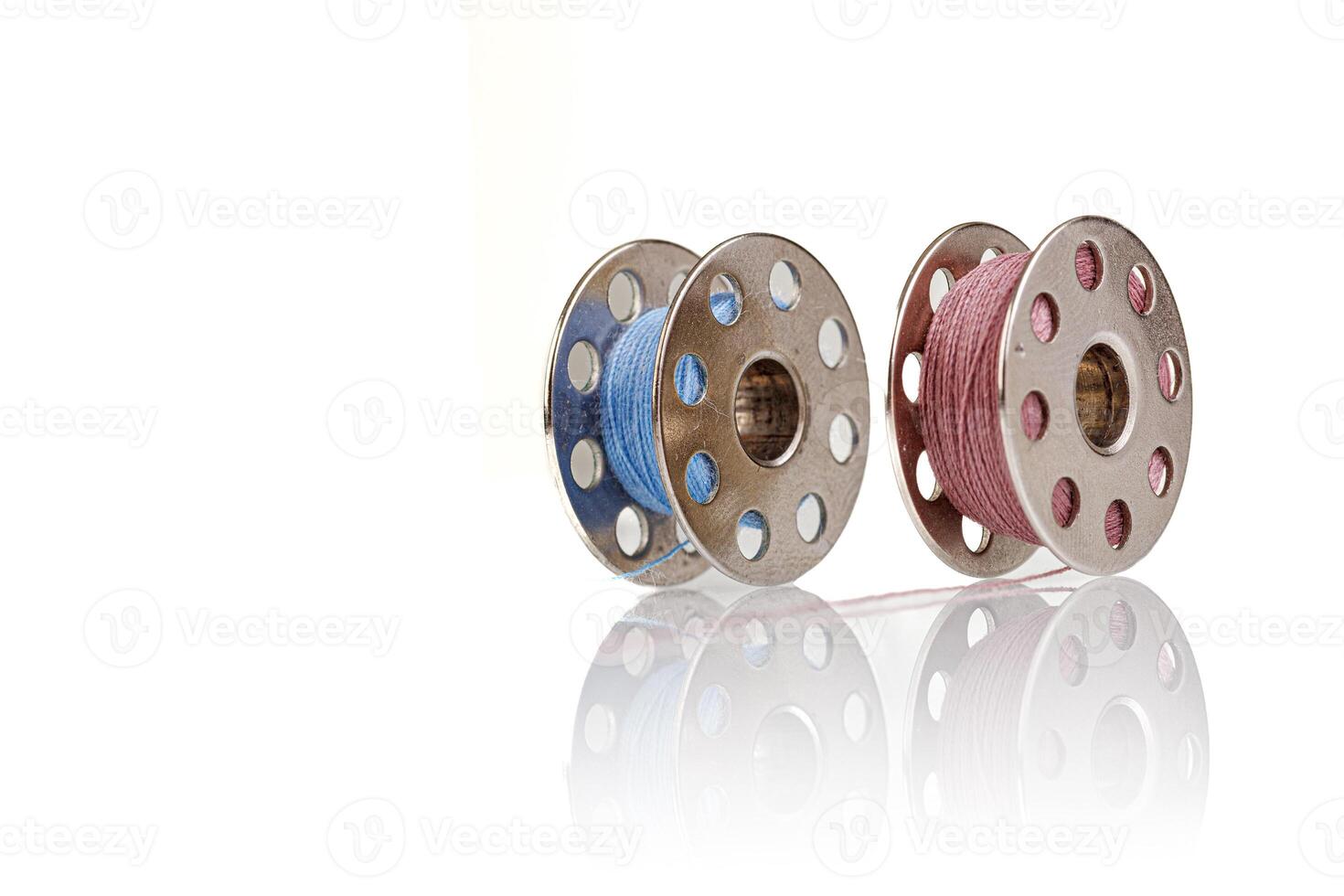 spools of blue and pink thread on a white background photo