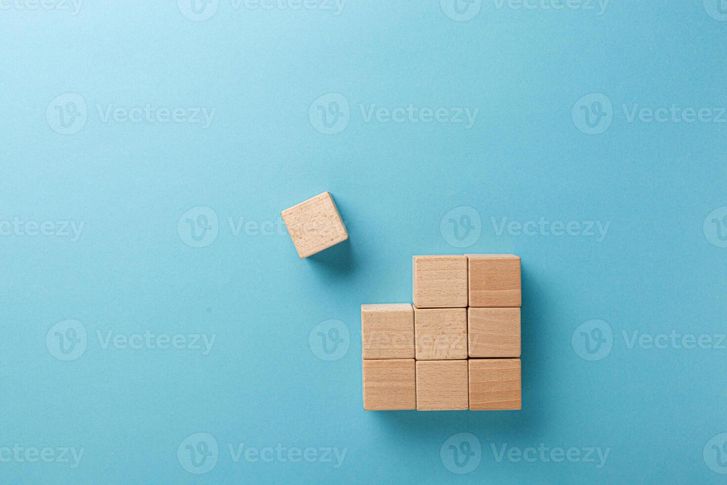 wooden cubes in a square of nine pieces in a row on a blue background photo